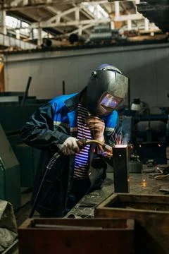 Welder working with electrode at semi-automatic arc welding. Stock Photos