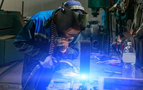 Welder working with electrode at semi-automatic arc welding. Stock Photos