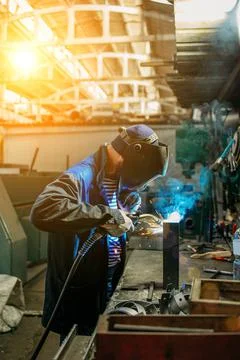 Welder working with electrode at semi-automatic arc welding. Stock Photos