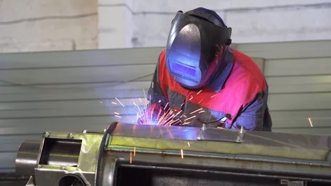 Welder working hard on complex part, blue glow, face mask, professional at work Stock Footage 120063343