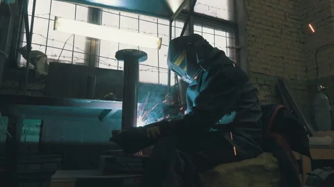 Welder Working on Industrial Pipe: Low Angle Shot of Worker in Protective Mask Stock Footage 343907026