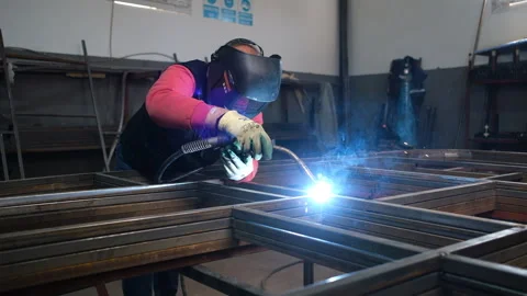 Welder working on metal framework with vibrant sparks flying Video stock 327592218
