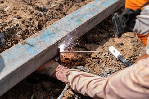 Welder working welding formwork on ground prefabricated concrete. Stock Photos