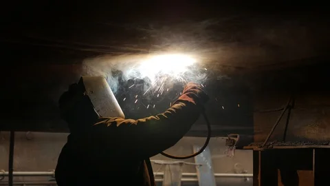 The welder works in the dock, under the hull of the ship Stock Footage 87320479