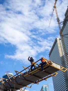 Welders at height on a concrete structure. The builder waves his hand. Work.. Stock Photos