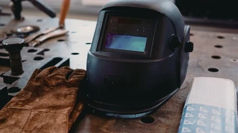 The welder's helmet is on the table next to other tools. Close-up shooting Stock Footage 141261285