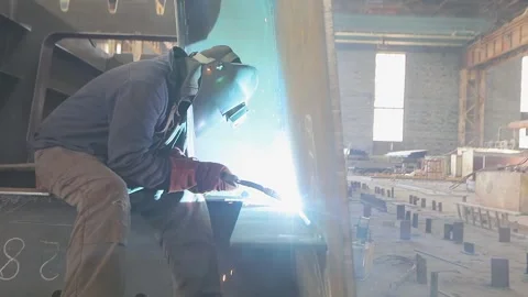 Welders weld large steel sections of a bridges box girder. Welders welding large Stock Footage 319938926