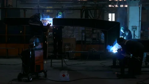 Welders weld large trailer frame at a factory. Stock Footage 197549155