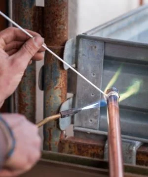 Welding of copper pipe. Stock Photos