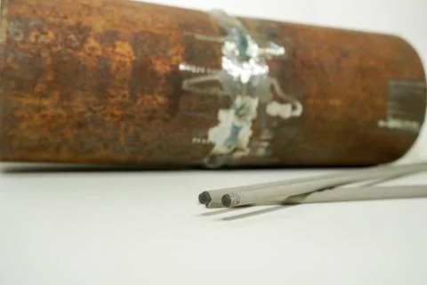 Welding electrode on the background sample of defective weld for testing in a Stock Photos