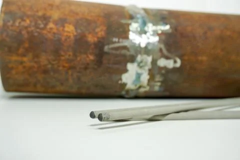 Welding electrode on the background sample of defective weld for testing in a Stock Photos
