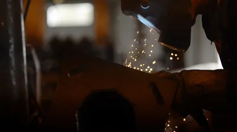 Welding Engineer completes the weld metal. lot of bright sparks, smoke and light Vidéo 57513601