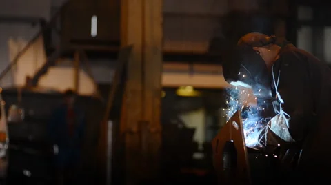 Welding Engineer weld attaching the base of pipes.a lot of bright sparks, smoke Stock Footage 57513547