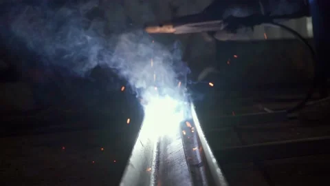 Welding in the focus will make sparks in the foreground corner. Stock Footage 157976402