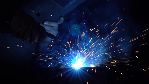 Welding iron pieces while creating blue sparks Stock Footage 98432735
