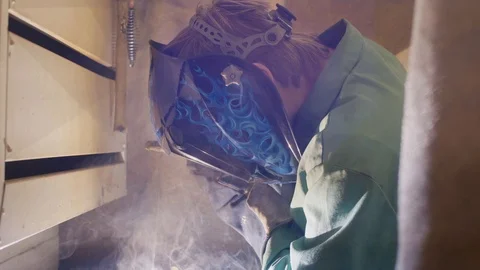 Welding a piece of metal in a booth Stock Footage 103337182