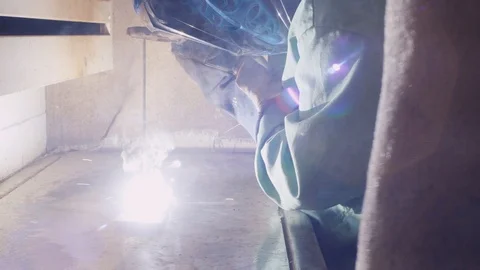 Welding a piece of metal in a booth Stock Footage 103337229