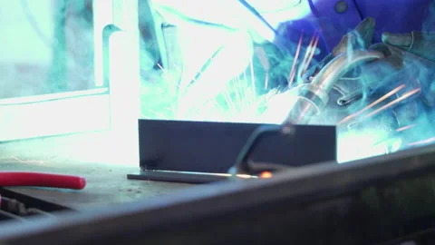 Welding sparks with blasting light behind metal plate masking gun tip Stock Footage 194610924