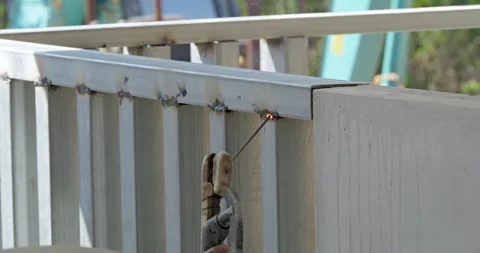 Welding sparks ignite action sequence in close-up at an outdoor industrial Stock Footage 330984982