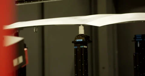 Welding tool flashes blue light beneath a metal panel on a production line Vídeo Stock 331446743