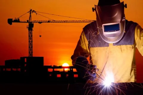 Welding worker welding steel structure with construction crane and building Photos