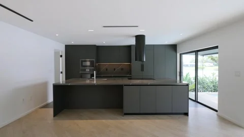 Well appointed kitchen in dark grey colour with marble worktops and recessed Stock Footage 282256564