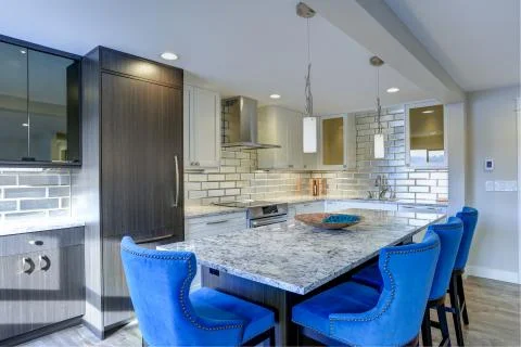 Well appointed kitchen features a large kitchen island topped with a gray qua Stock Photos