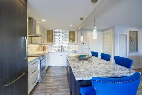 Well appointed kitchen features a large kitchen island topped with a gray qua Stock Photos