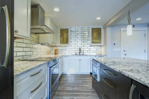 Well appointed kitchen features a large kitchen island topped with a gray qua Stock Photos