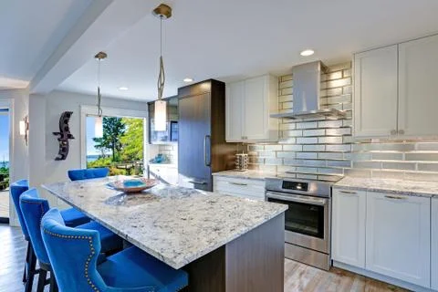 Well appointed kitchen features a large kitchen island topped with a gray qua Stock Photos