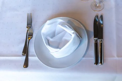 A well-arranged dining table features a polished plate with a folded white na Stock Photos