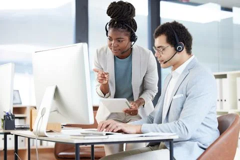Well be implementing these new systems. two call centre agents working together 스톡 사진