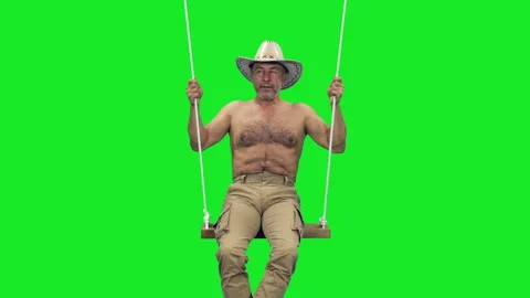 A well-built middle aged man swinging on beach swing on green screen 스톡 동영상 305189736