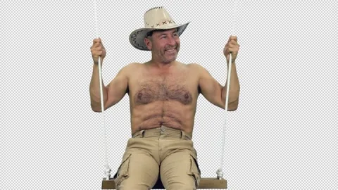 A well-built middle aged man wearing cowboy hat swinging on beach swing, alpha Stock Footage 306095856