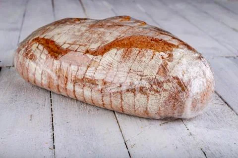 Well done bread wrapped in plastic wrap. Food prepared for transport. Stock Photos