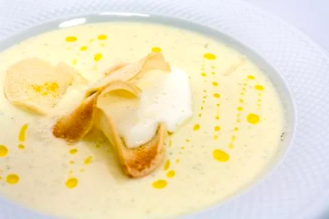 Well-done thin slices of croutons in a creamy soup mashed butter in a white p Stock Photos