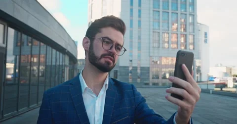 Well dressed man with Beard have video chat a Phone in Town. Stock Footage 168352483