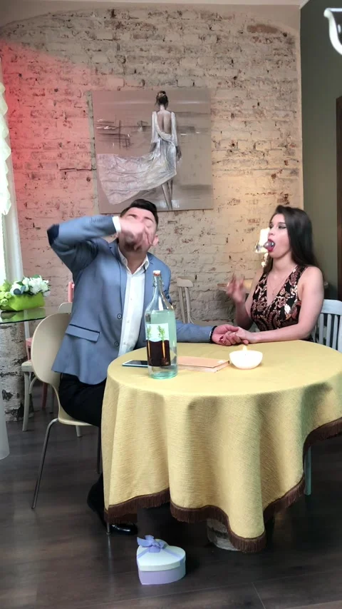 A well-dressed man drinking alcoholic shots with his beautiful wife Stock Footage 236925546