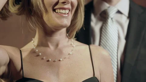 Well-dressed man helps date with her necklace - close-up shot Stock Footage 42891269