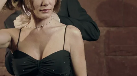 Well-dressed man helps date with her necklace - medium shot Stock-Footage 42891355