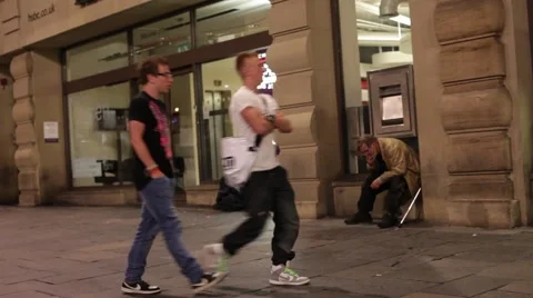 Well dressed men pass sick homeless man on street next to bank homelessness Stock Footage 41234521