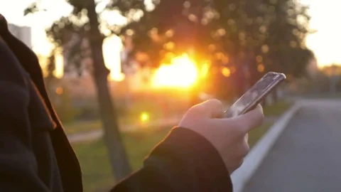 Well-dressed trendy man talking with mobile phone in a city on sunset time Stock Footage 80940402