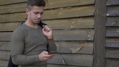 Well-dressed trendy man talking with mobile phone in a city on sunset time Video stock 80986676