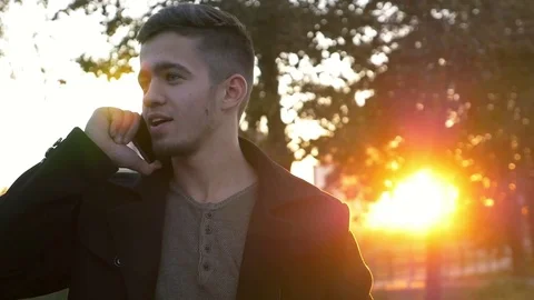 Well-dressed trendy man talking with mobile phone in a city on sunset time Video stock 80993759