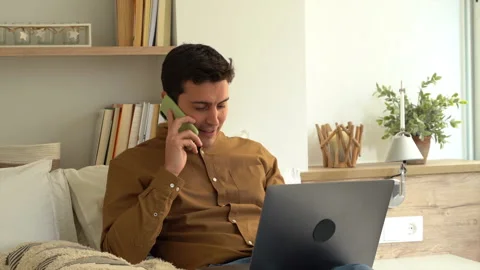 Well-dressed young man working with his laptop in the room Answering a call. Video stock 146941933