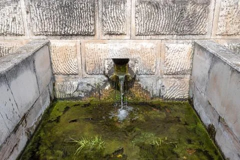 A well that flows from an old architecture Stock Photos