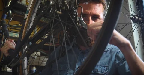 Well-groomed handsome bearded master hipster, specialist in bicycles Stock Footage