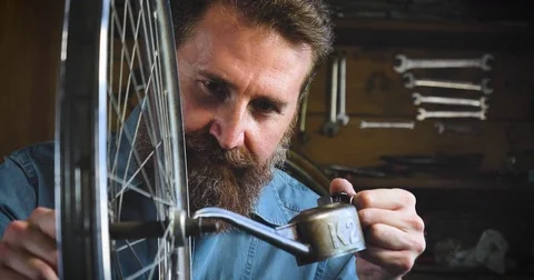 Well-groomed handsome bearded master hipster, specialist in bicycles Stock Footage
