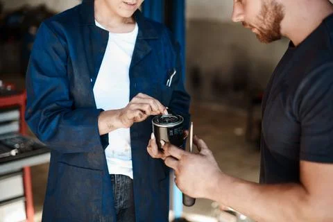 Well have to replace this. Shot of two mechanics looking at a fuel filter whi 스톡 사진