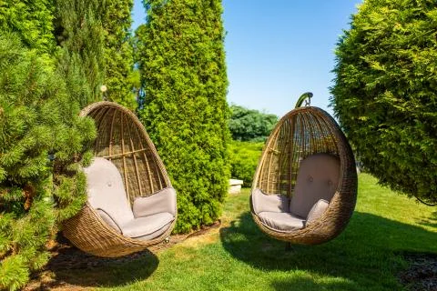 Well-kept green garden. Great cozy place to stay. Wicker Chair Nest Stock Photos